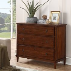 a wooden dresser with two plants on top