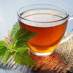 a glass cup filled with green tea sitting on top of a table