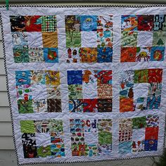 a quilt hanging on the side of a house