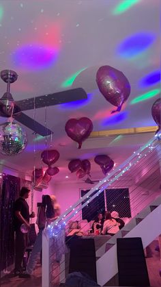 a room filled with lots of balloons and disco balls hanging from the ceiling above it