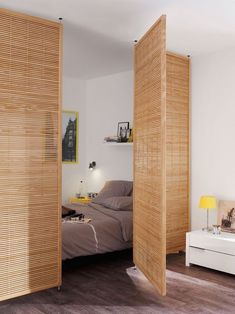 a bedroom with wooden slats on the walls and a bed in the corner between two doors