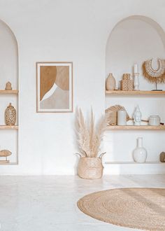 a living room with white walls and shelves filled with vases, plants and other items