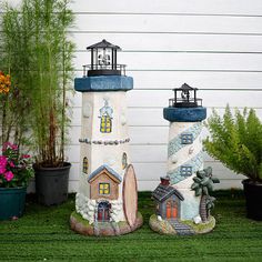 two decorative lighthouses are sitting in the grass