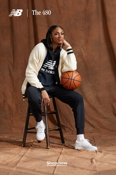 a woman sitting in a chair holding a basketball