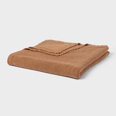 a brown blanket folded on top of a white surface