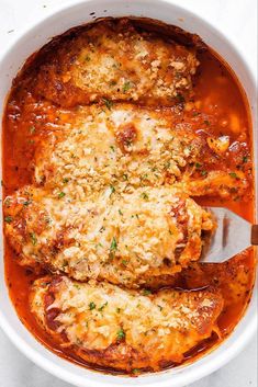 chicken parmesan in a white bowl with a spoon