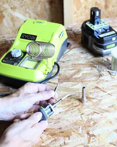 a person is working with some tools on a wooden table in the process of making something