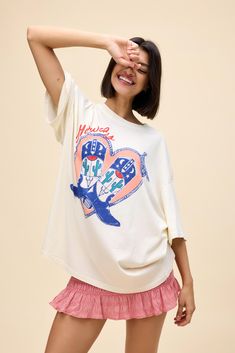 a woman posing with her hands behind her head and wearing a white t - shirt