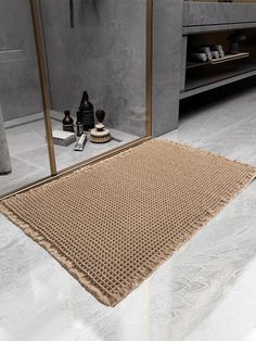 a bathroom area with a large mirror, sink and toiletries on the floor in front of it