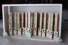 several pieces of wood with writing on them in a white box, sitting on a table