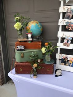 a stack of suitcases sitting on top of a table next to a clock and flowers