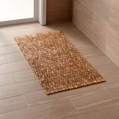 a bathroom with tile flooring and a rug on the ground in front of it