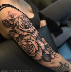 a black and white rose tattoo on the arm