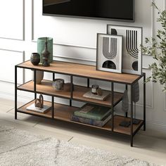 a television is mounted on the wall next to a shelf with books and vases