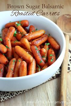 a white bowl filled with carrots on top of a wooden table