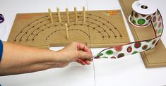 a person is making a craft project with tape and wooden dows on the table