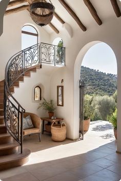 a staircase leading up to the upper level of a house with stone floors and arches