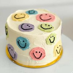 a white cake with smiley faces on it