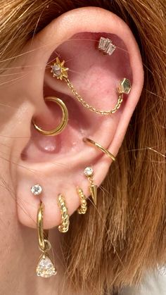 a close up of a person's ear with three different types of piercings