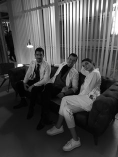 three people sitting on a couch in a room