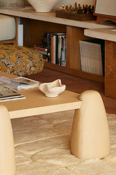 a living room with a couch, table and bookshelf filled with books on top of it