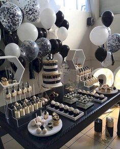 a table topped with lots of black and white balloons