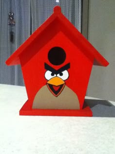 a red birdhouse sitting on top of a table