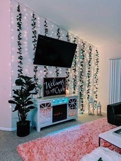 a living room with christmas lights and a flat screen tv on top of a entertainment center