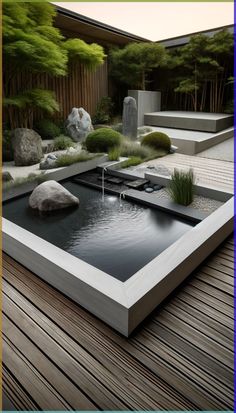 a garden with rocks, water and plants on the ground in front of a wooden deck