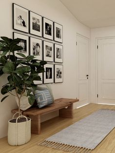 a living room with pictures on the wall and a rug in front of a couch