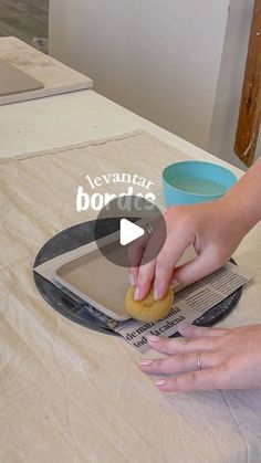 a woman is using a tablet to do something on top of the table with her hands