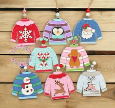 christmas sweater ornaments hanging on a wooden wall