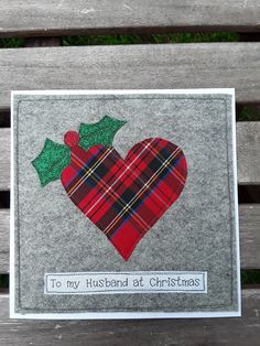 a handmade christmas card on a park bench with holly and plaid heart, says to my husband at christmas