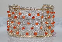 an orange beaded bracelet on a white surface