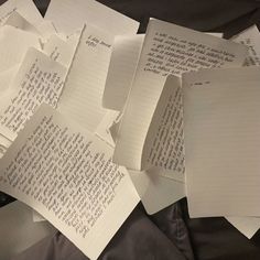 several pieces of paper with writing on them sitting on a black sheet of paper next to each other