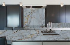 a kitchen with marble counter tops and stainless steel appliances