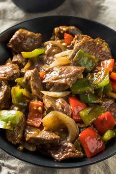 a bowl filled with beef and vegetables on top of a table