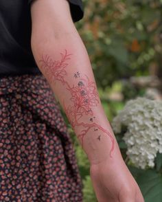 a woman with a tattoo on her arm holding onto a white and pink flower bouquet