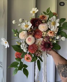 a person holding a bouquet of flowers in their hand