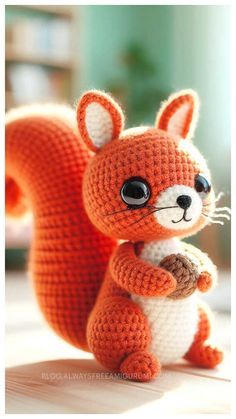 a crocheted fox is sitting on the floor with its tail up and eyes wide open