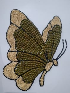 a beaded butterfly sitting on top of a white surface