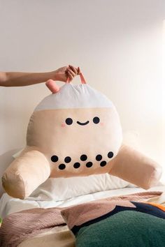 a person holding a large stuffed animal on top of a bed