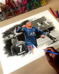 a drawing of a soccer player is being displayed on a table with colored pencils