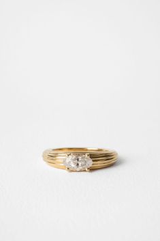 a gold ring with two diamonds on the top and bottom, set against a white background