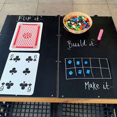 two tables with playing cards, dices and a bowl of candy on top of them