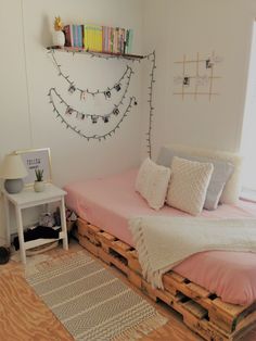 a bed made out of pallets with pillows and blankets on it in a bedroom