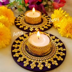 two small candles are sitting on plates with flowers in the background and an inscription that reads arty artsy