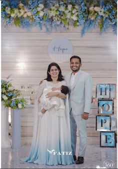 a man and woman standing next to each other in front of a sign that says hope