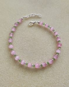 This is a very pretty and elegant bracelet that sparkles just right.  The pink glass beads go well with the small green Swarovski crystals and sterling silver beads.  This bracelet makes me think of Easter time, and really, spring and summer time.  Its beautiful pastel shades make it appropriate for this time of year.  With the sterling silver extender, the necklace can extend up to 9 and 1/2 inches. Pink Beaded Sterling Silver Bracelets, Tiny Bead Bracelet, Cute Friendship Bracelets, Diy Jewelry Rings, Pretty Jewelry Necklaces, Spring Bracelet, Bracelet Craft Diy, Fun Bracelet, Bracelets Design