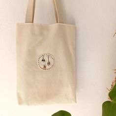 a tote bag hanging on the wall next to a plant